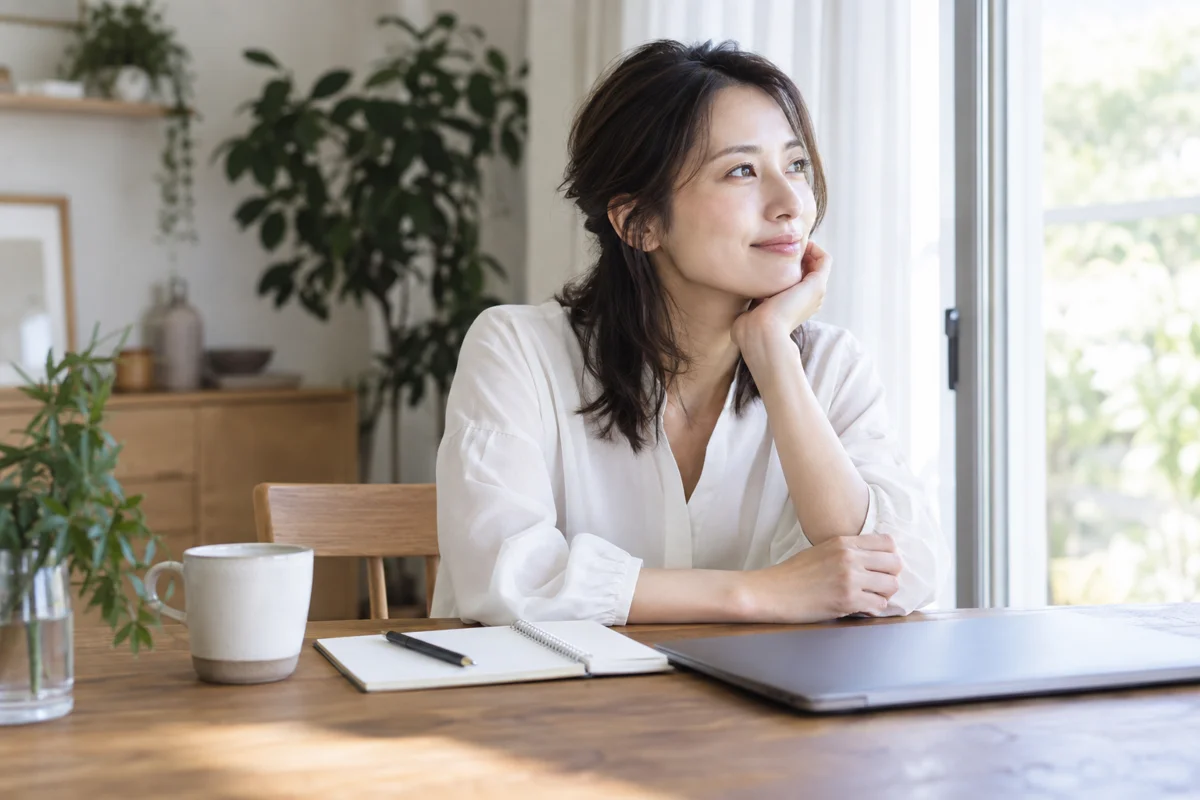 退職後の暮らしについて窓辺で考える会社員の女性のイメージ
